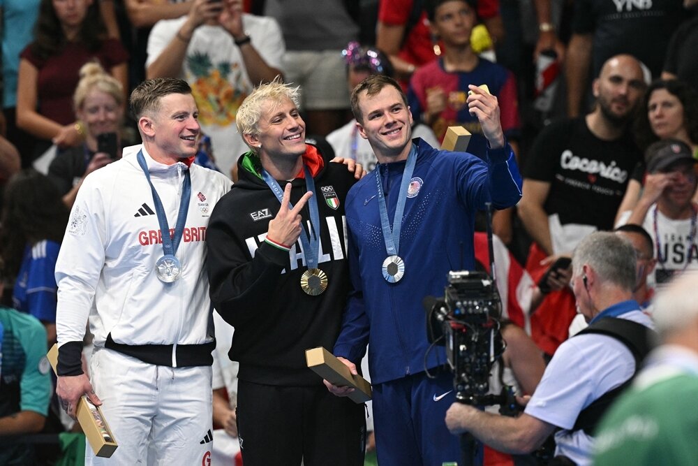 본문 이미지 - (왼쪽부터) 2024 파리 올림픽 수영 남자 평영 100m 시상식에서 애덤 피티(Adam Peaty, 영국), 니콜로 마르티넨기(Nicolo Martinenghi, 이탈리아), 닉 핑크(Nic Fink, 미국) 선수가 빅토리 셀피를 찍고 있는 모습.(삼성전자 제공)