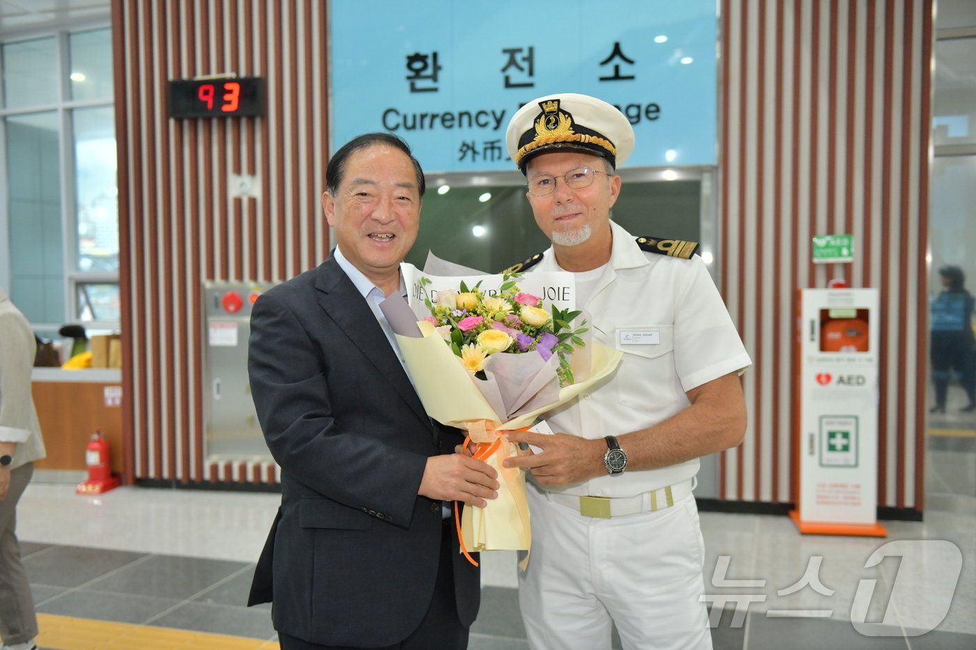 본문 이미지 - 이병선 속초시장이 12일 속초항을 출발해 일본으로 출항하는 11만 톤 급 대형 크루즈 '코스타 세레나'호 캡틴을 만나 꽃다발을 전달하고 있다.(속초시 제공) 2024.9.12/뉴스1