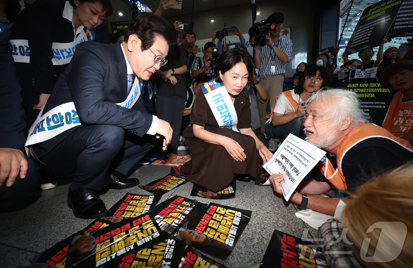 이재명 더불어민주당 대표가 13일 오전 서울 용산구 용산역에서 추석 귀성인사를 하던 도중 박경석 전국장애인차별철폐연대&#40;전장연&#41; 대표의 7대 장애인권리입법 제정 호소를 듣고 있다. 2024.9.13/뉴스1 ⓒ News1 김민지 기자