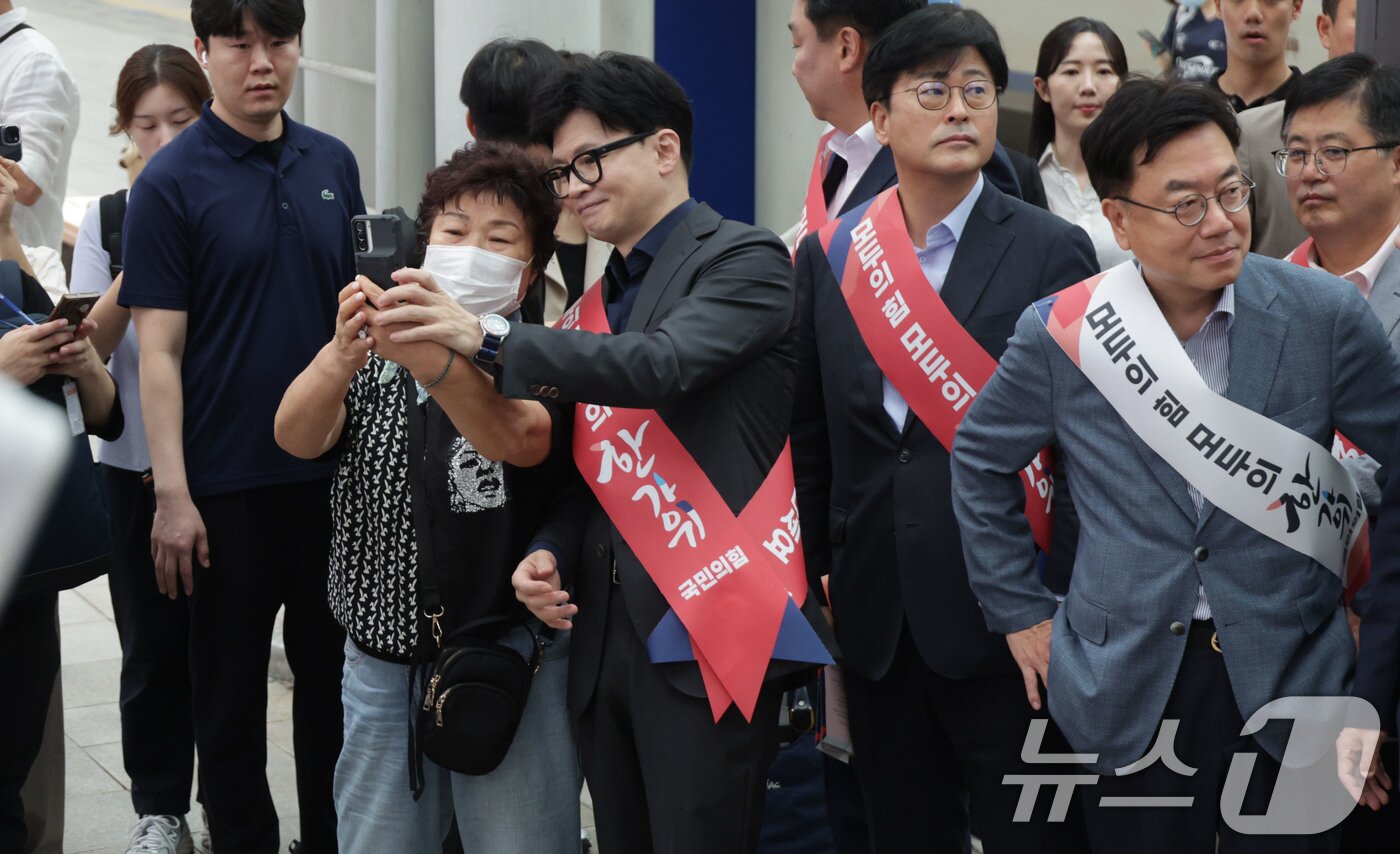 한동훈 국민의힘 대표가 13일 오전 서울역에서 지도부와 함께 추석 귀성 인사를 하던 중 한 시민과 셀카를 찍고 있다. &#40;공동취재&#41; 2024.9.13/뉴스1 ⓒ News1 이동해 기자