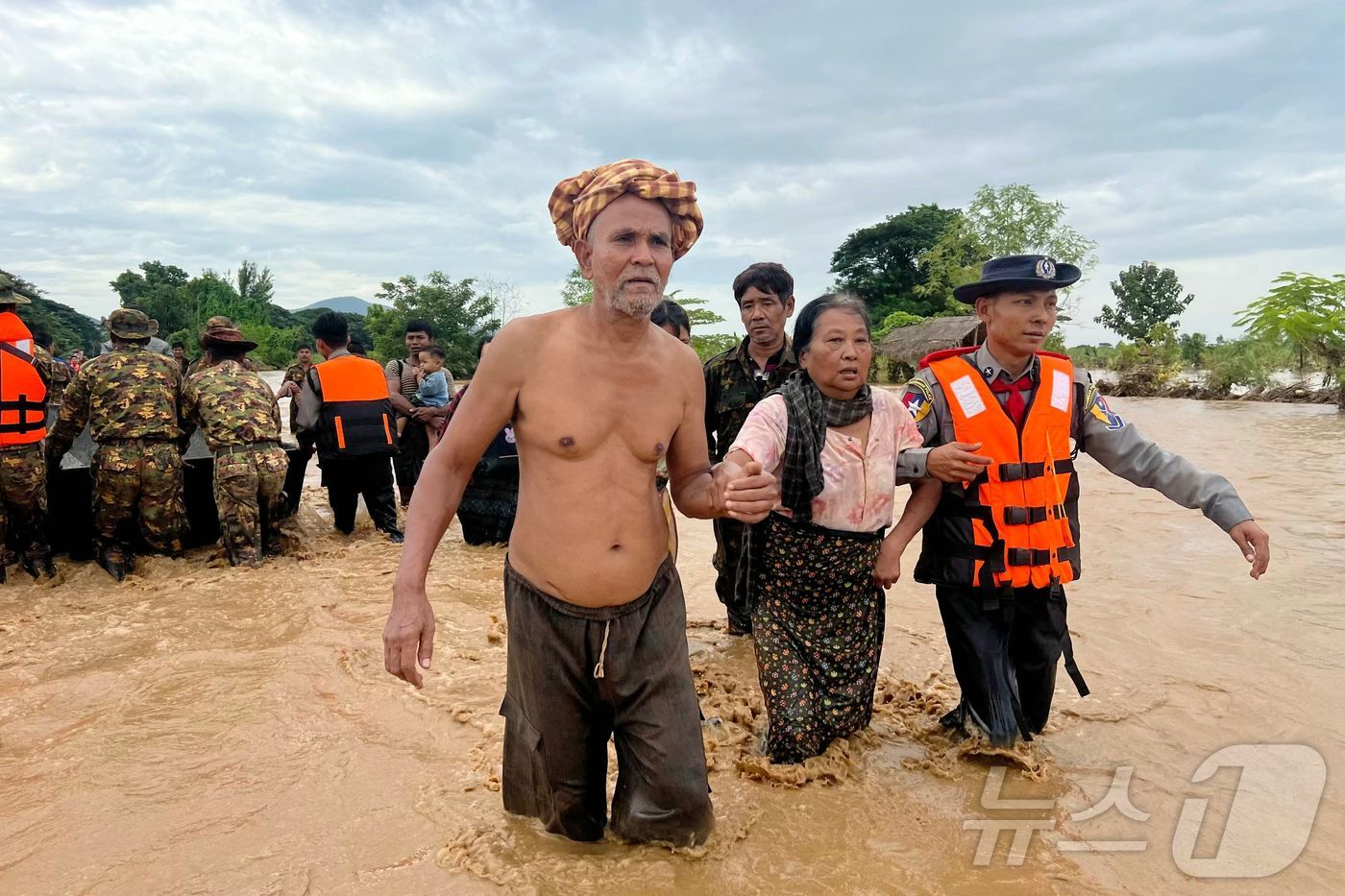 (핀마나 AFP=뉴스1) 김지완 기자 = 13일 미얀마 네피도 지역의 핀마나 마을 주민들이 경찰의 도움을 받아 흙탕물을 헤치고 걸어가고 있다. 한편 베트남, 라오스, 태국과 미얀마 …