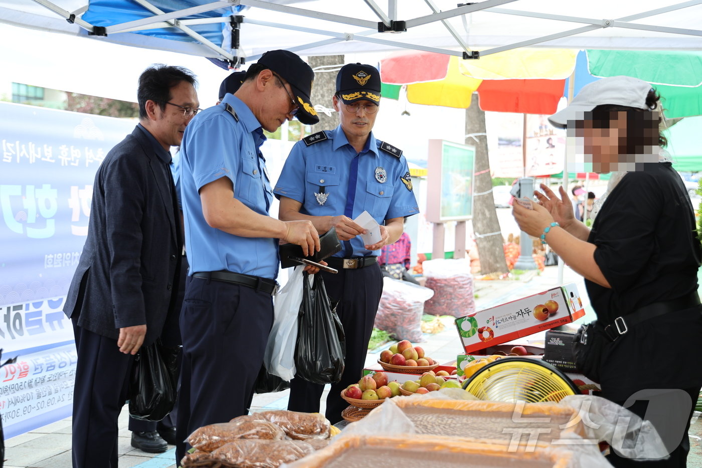 본문 이미지 - 추석 연휴를 앞둔 13일 김성종 동해지방해양경찰청장이 강원 동해시 북평민속시장을 방문해 먹거리를 구입하고 있다.(동해해경청 제공) 2024.9.13/뉴스1