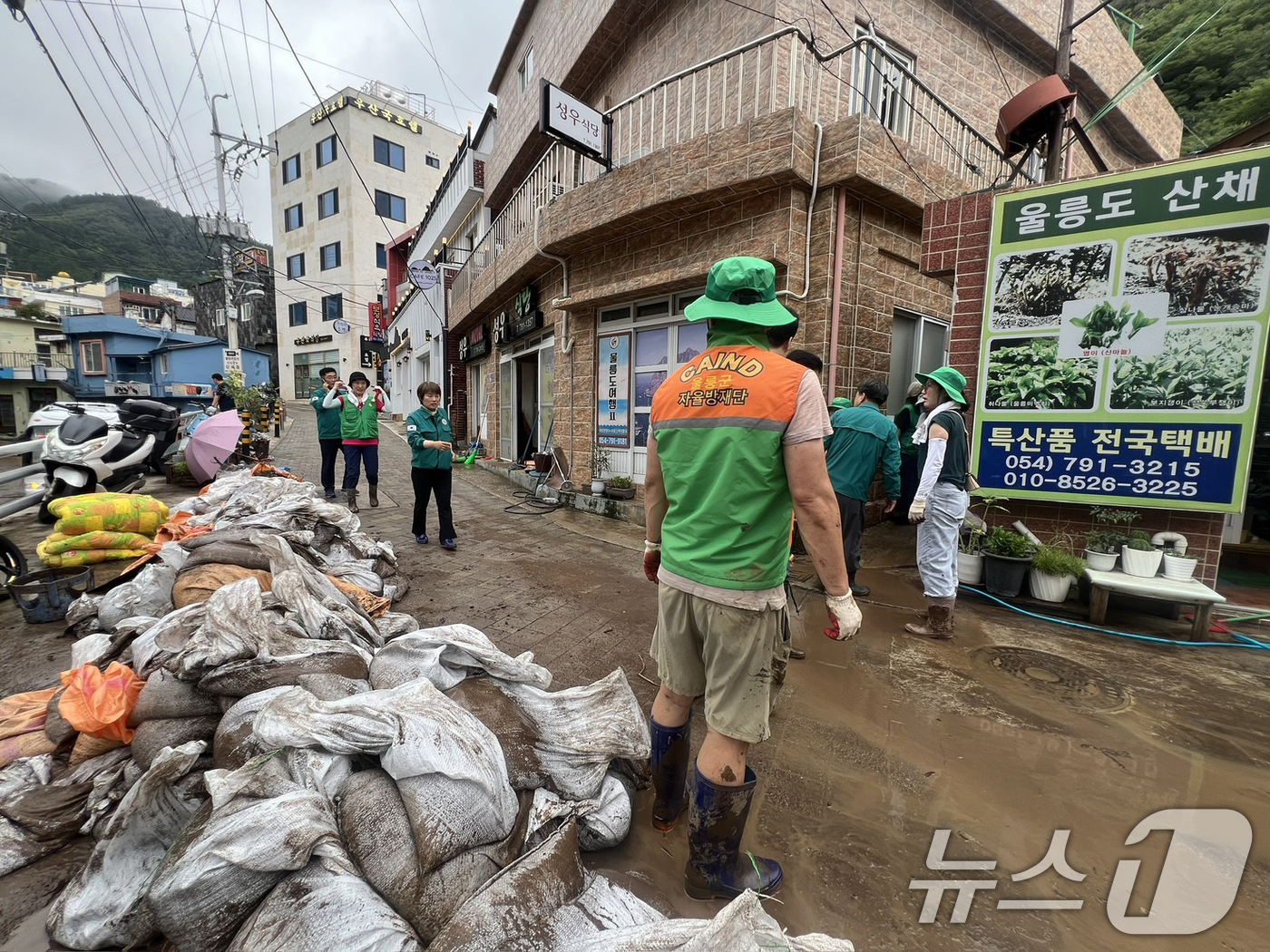 (울릉=뉴스1) 최창호 기자 = 13일 오전 경북 울릉군 공무원과 시민들이 폭우로 도로에 쌓여있던 토사 와 쓰레기들을 치우고 있다. 울릉군은 이번 주중으로 토사 제거 등 복구 작업 …