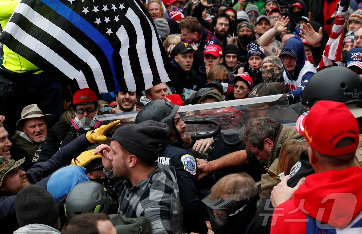 본문 이미지 - 도널드 트럼프 미국 전 대통령을 지지하는 시위대가 2020년 대선 결과에 이의를 제기하며 미국 워싱턴DC에 있는 국회의사당 앞에서 '파란색 얇은 선' 깃발을 휘두르고 있다. 2021.01.06 ⓒ 로이터=뉴스1 ⓒ News1 정지윤 기자