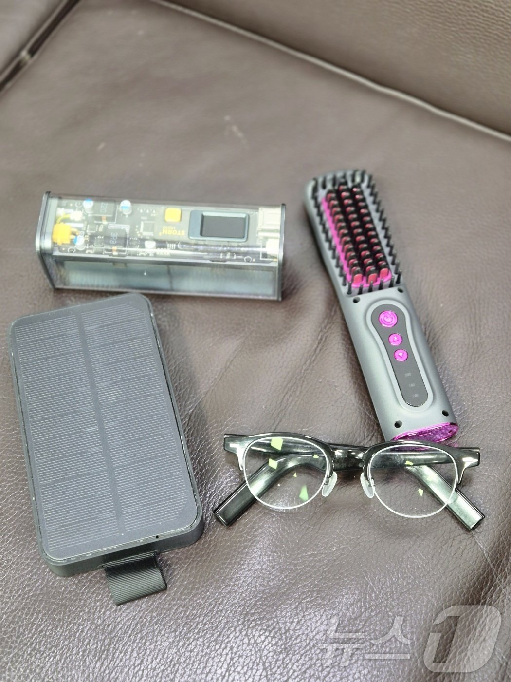 본문 이미지 - 김우영 의원이 평소 사용하는 초고속 무선충전기 (좌측 상단)과 태양광 충전 무선충전기 (좌측 하단), 그리고 무선 헤어브러쉬 (우측)이다. ⓒ 뉴스1 임세원 기자