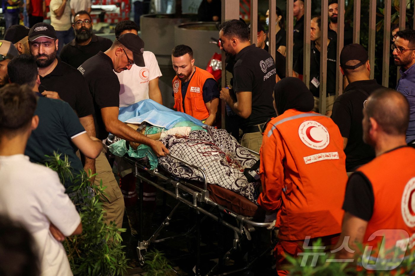 본문 이미지 - 17일(현지시간) 레바논 베이루트의 아메리칸 대학 베이루트 의료센터에서 구급대원들이 현지 무장정파 헤즈볼라의 호출기 동시 폭발로 인해 부상당한 사람을 들것에 실어 이송하고 있다. 레바논 전역에서 발생한 이번 폭발로 인한 부상자는 헤즈볼라 대원과 의료진을 포함해 1000명이 넘었다. 2024.09.17 ⓒ 로이터=뉴스1 ⓒ News1 김지완 기자