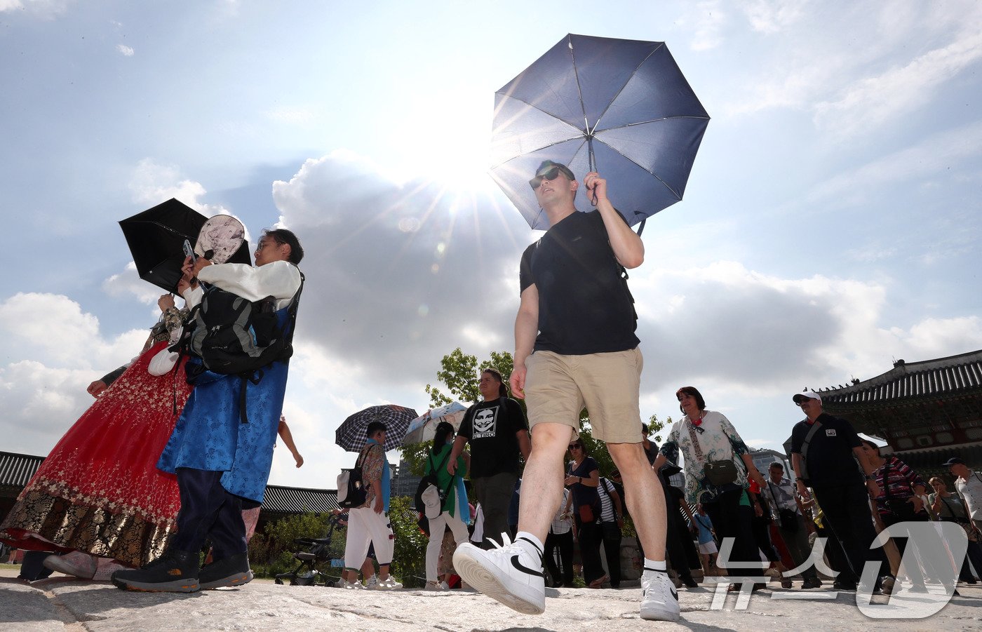 본문 이미지 - 서울에 폭염주의보가 내려진 18일 종로구 경복궁을 찾은 외국인 관광객이 양산을 쓰고 이동하고 있다. 2024.9.18/뉴스1 ⓒ News1 박세연 기자