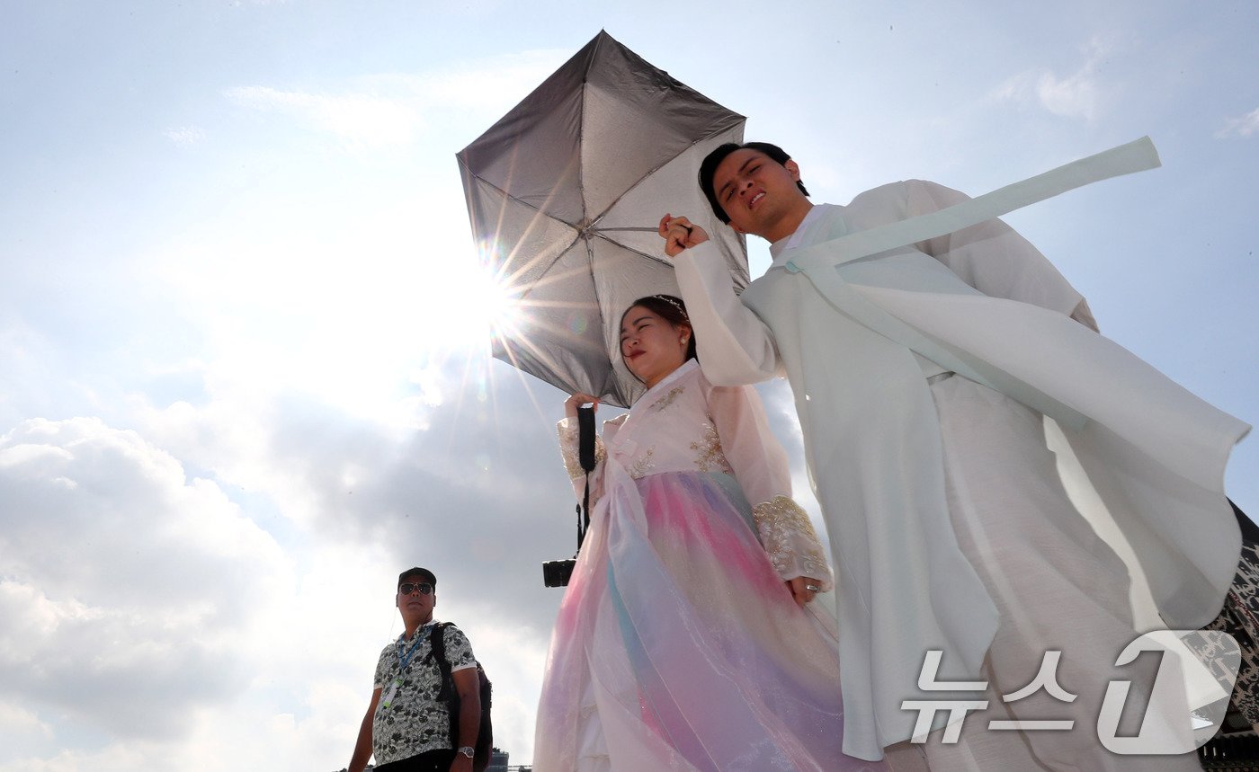 본문 이미지 - 서울에 폭염주의보가 내려진 18일 종로구 경복궁을 찾은 외국인 관광객이 양산을 쓰고 이동하고 있다. 2024.9.18/뉴스1 ⓒ News1 박세연 기자