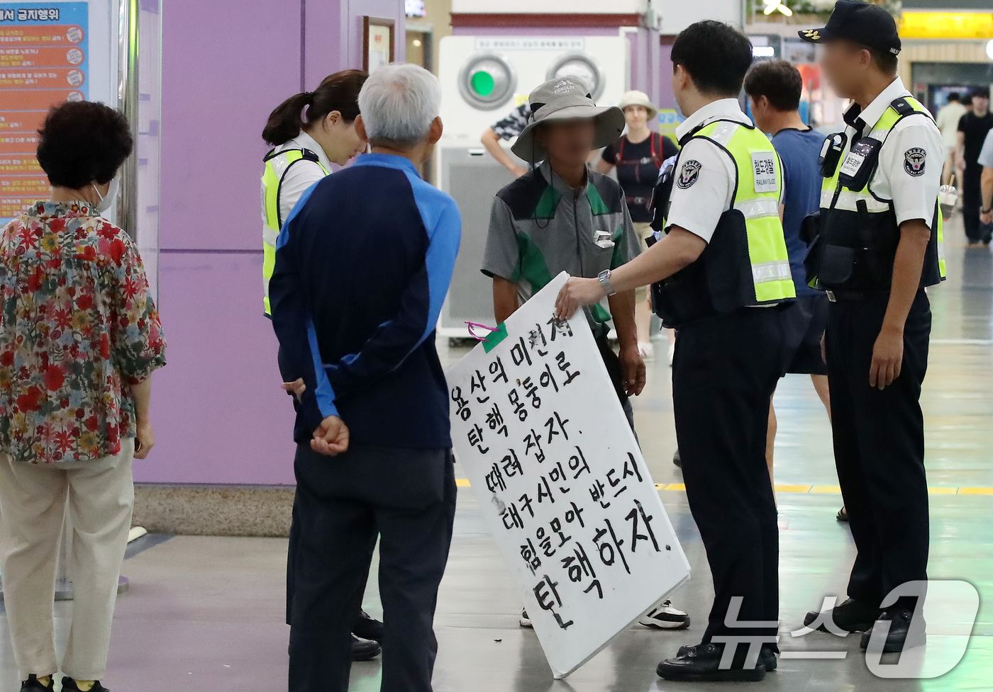 (대구=뉴스1) 공정식 기자 = 추석 연휴 마지막 날인 18일 오전 대구 동구 동대구역 대합실에서 한 남성이 탄핵 관련 문구가 적힌 피켓을 들고 고성을 지르다 철도경찰에 제지당하고 …