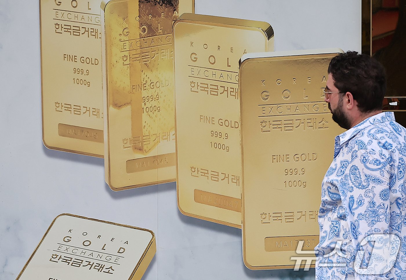본문 이미지 - 미국 연준의 0.5% 포인트의 금리 인하 발표에 금 가격이 사상 최고치를 경신한 19일 서울 종로구 한국금거래소에서 한 외국인 관광객이 골드바 홍보물 앞을 지나고 있다. 2024.9.19/뉴스1 ⓒ News1 김진환 기자