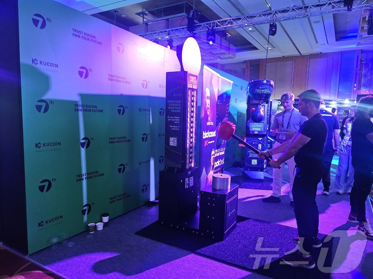 본문 이미지 - 지난 18일부터 19일까지 싱가포르에서 열린 '토큰2049' 행사 현장. 한 참가자가 부스에서 게임을 즐기고 있다.