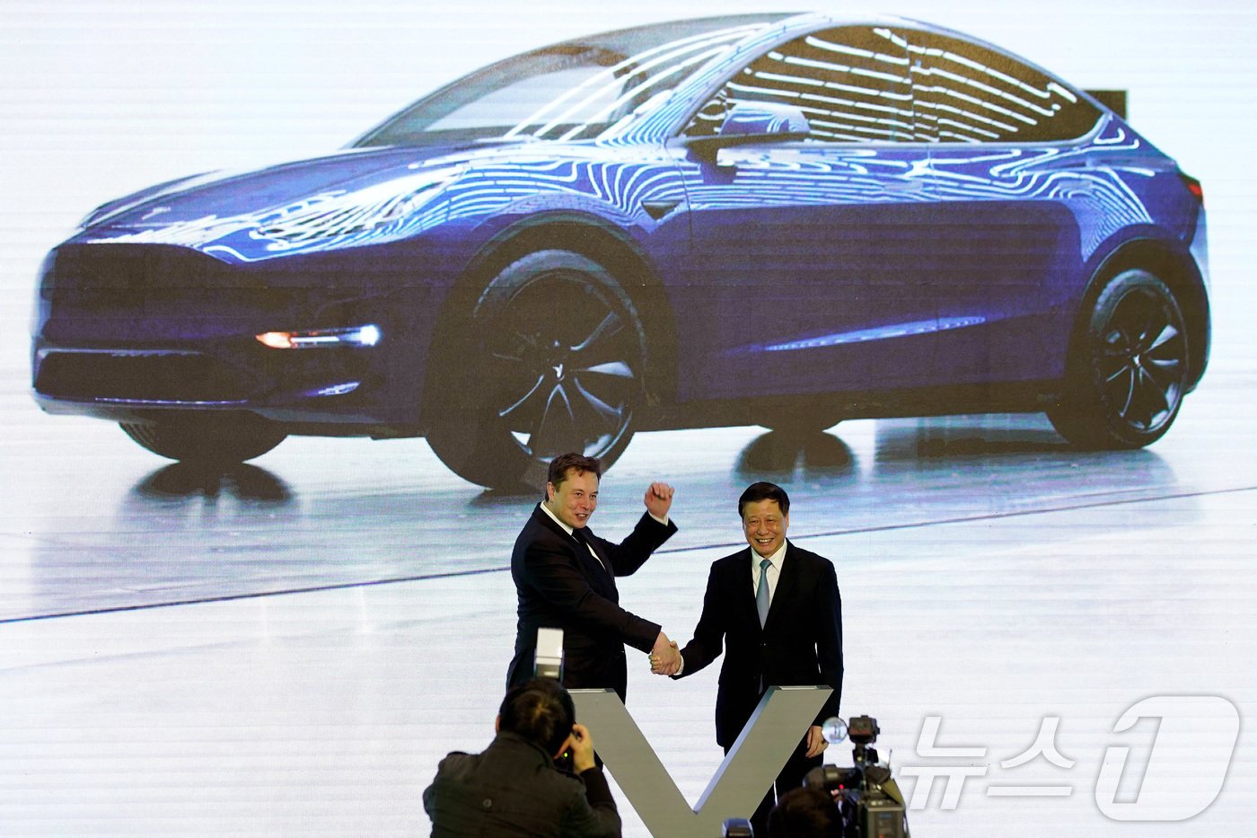 본문 이미지 - 테슬라가 생산하는 모델Y 차량 앞에서 일론 머스크 최고경영자와 잉용 상하이 시장이 악수하고 있다. ⓒ 로이터=뉴스1 ⓒ News1 박형기 기자
