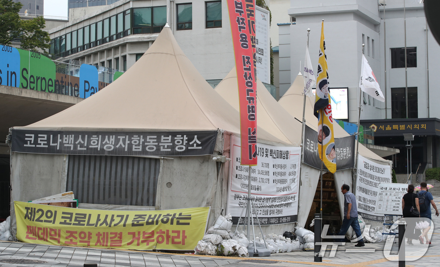 (서울=뉴스1) 임세영 기자 = 2일 오전 서울 중구 서울시의회 앞에 설치된 '코로나19 백신 희생자 합동분향소' 앞을 한 시민들이 지나고 있다.3년째 농성을 이어가고 있는 '코로 …