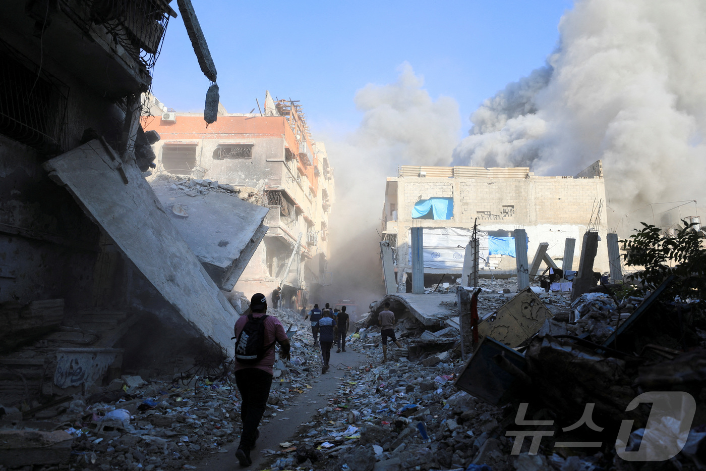 (로이터=뉴스1) 유수연 기자 = 1일(현지시간) 가자지구에서 팔레스타인인들이 이스라엘의 공습으로 파괴된 학교 현장을 걷고 있다. 이 학교는 이재민들을 대피시키던 장소였다. 202 …