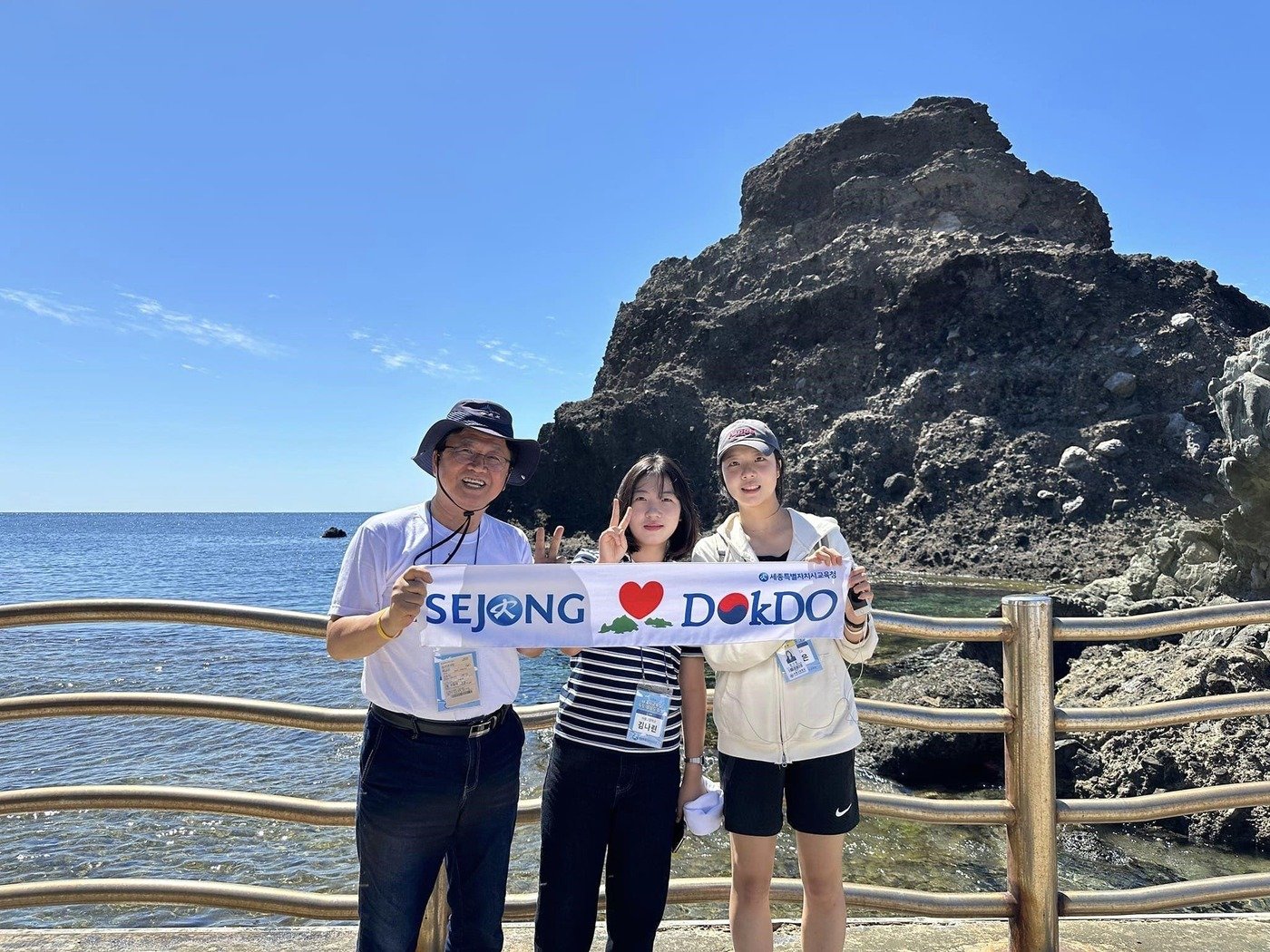  최교진 세종교육감&#40;왼쪽&#41;과 독도 탐방학생들이 1일 독도에 입도해 &#39;SEJONG&#40;세종&#41; ♡ DOKDO&#40;독도&#41;&#39; 글귀가 새겨진 수건을 들고 사진 촬영을 하고 있다. &#40;세종교육청 제공&#41; / 뉴스1