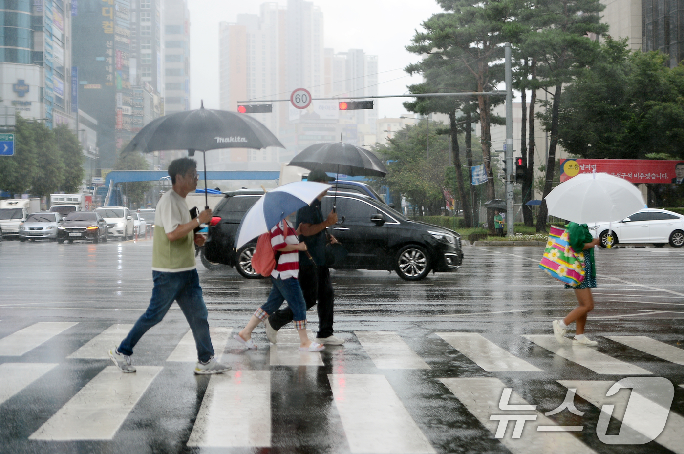 (광주=뉴스1) 이승현 기자 = 가을비가 내리고 있는 20일 광주 도심에서 시민들이 우산을 쓴 채 길을 건너고 있다. 2024.9.20/뉴스1