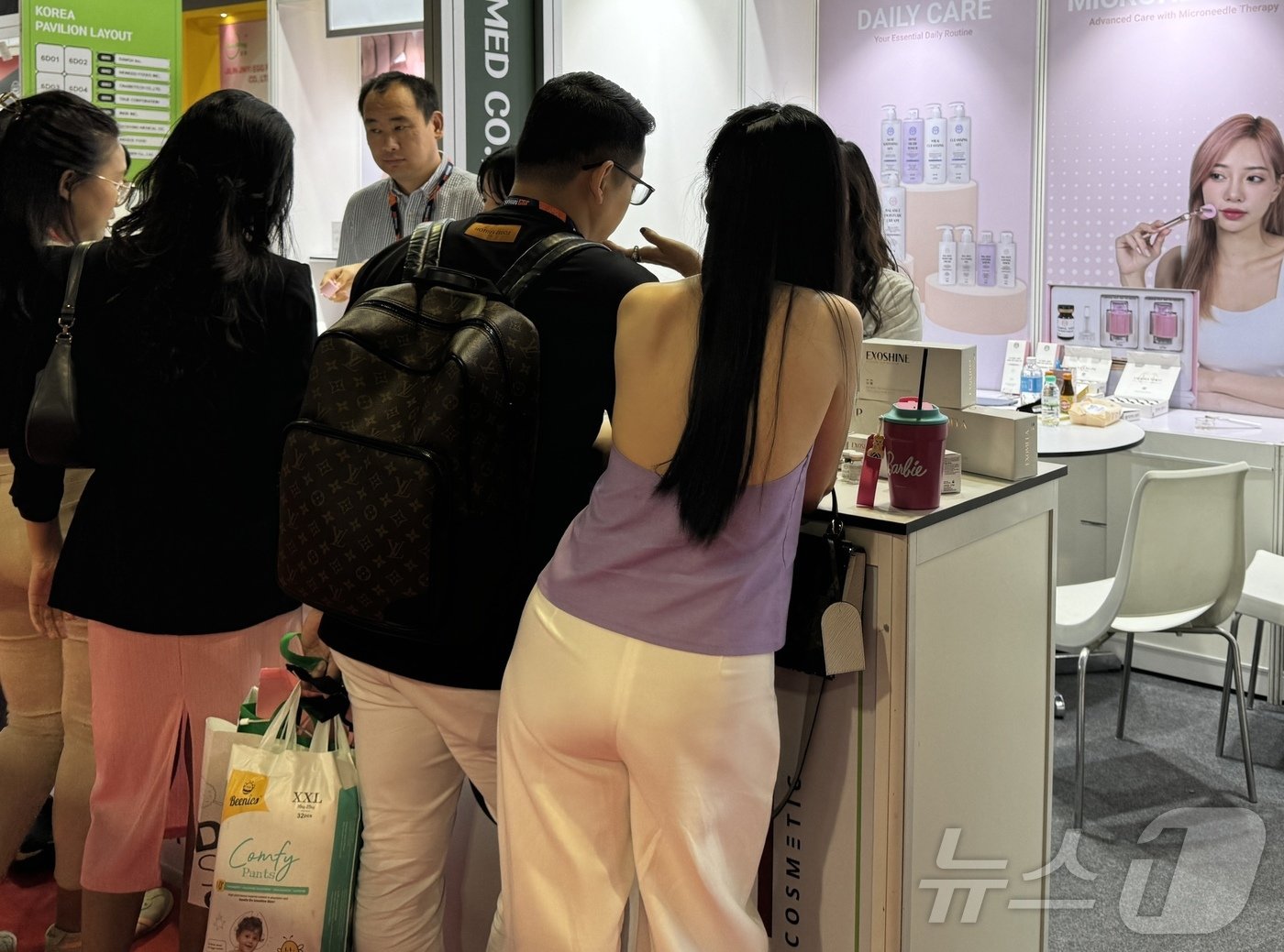 본문 이미지 - 미하스&#40;MIHAS&#41; 박람회 한국 화장품 부스에 모인 사람들