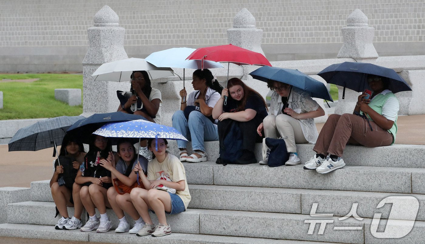 본문 이미지 - 비가 내리고 있는 20일 오후 서울 종로구 경복궁을 찾은 외국인관광객들이 우산을 쓰고 비를 피하고 있다. 기상청은 내일까지 전국적으로 많은 비가 내린 후 폭염 기세가 꺾이겠다고 밝혔다. 2024.9.20/뉴스1 ⓒ News1 박세연 기자