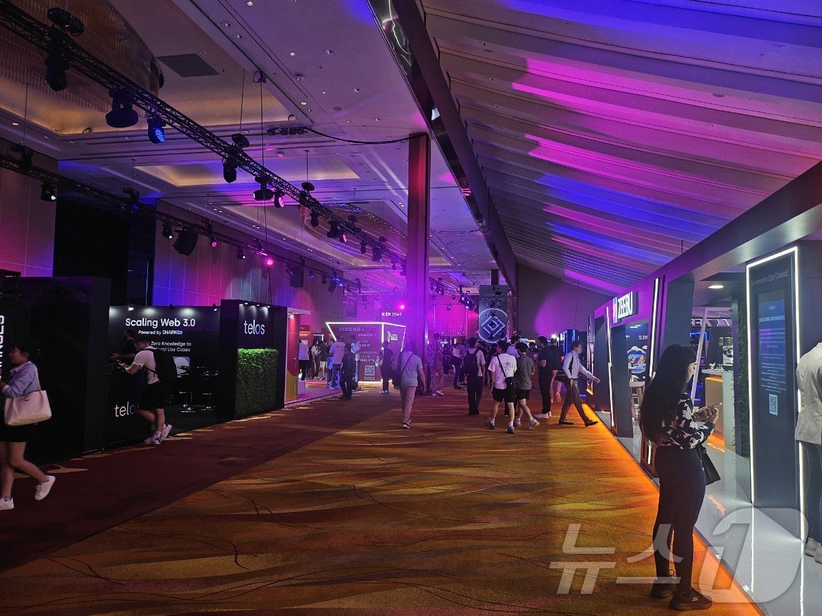 본문 이미지 - 전시 부스가 길게 늘어 서 있는 토큰2049 현장.