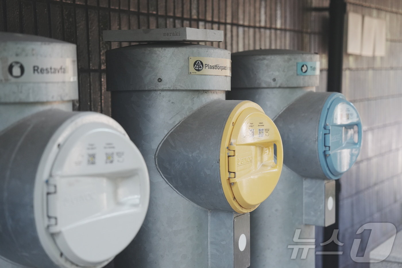 본문 이미지 - 8월 26일(현지시간) 스웨덴 스톡홀름 함마르뷔 셰스타드 지구 내 건물마다 쓰레기 진공 흡입구가 설치돼 있다. QR코드를 통해 개폐구를 연 뒤 쓰레기를 넣으면 채워질 때마다 자동으로 쓰레기를 한 곳으로 자동 집하한다. ⓒ 뉴스1 황덕현 기자