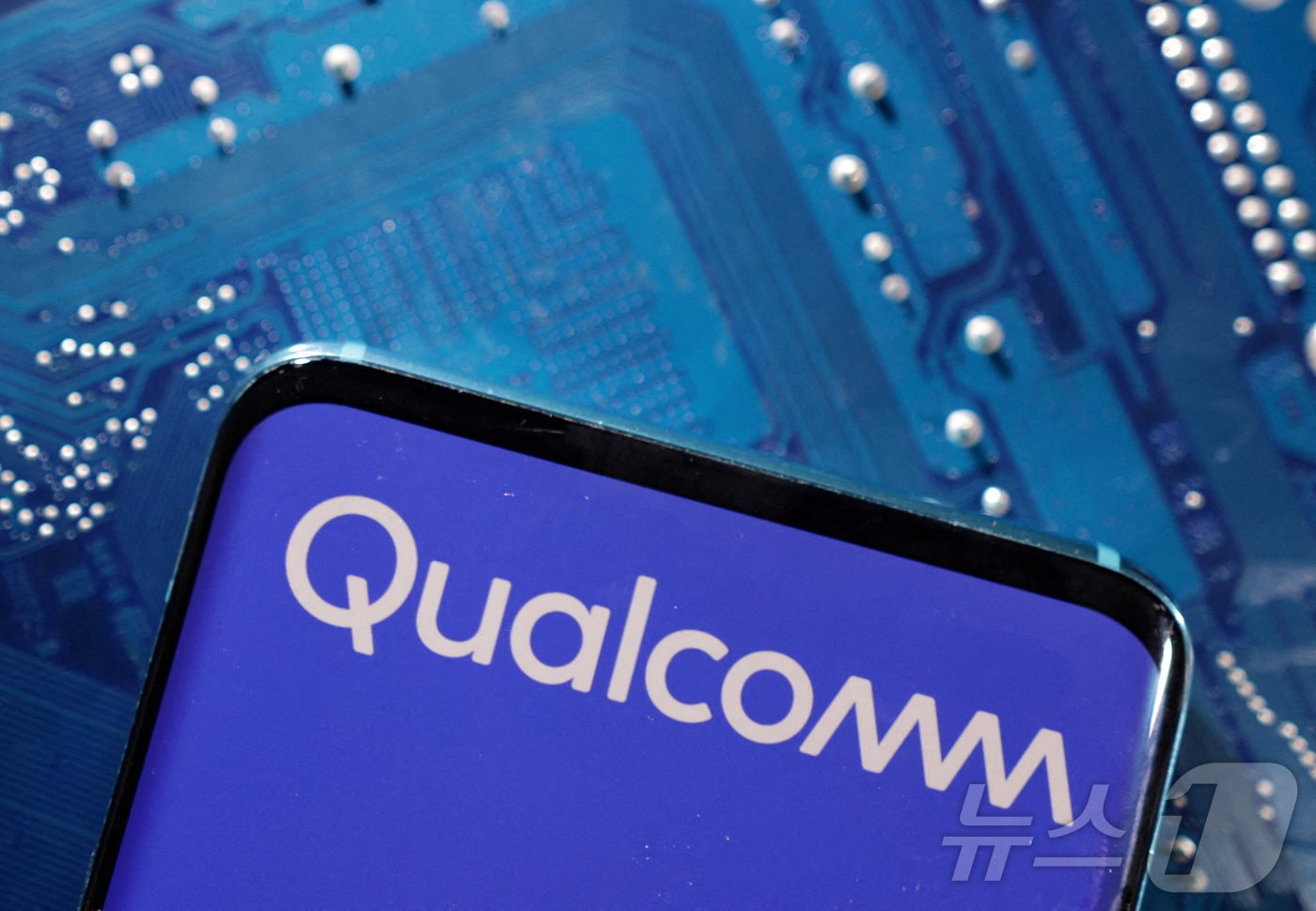 본문 이미지 - 휴대폰에 미국 반도체 업체 퀄컴의 로고가 나오고 있다. ⓒ 로이터=뉴스1 ⓒ News1 박형기 기자