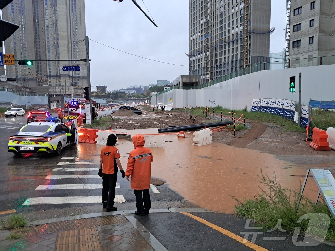본문 이미지 - 20일 오후 4시 26분께 일산동구 풍동 애니골길의 공사현장 인근 임시 인도가 집중호우로 인해 침수되자 소방당국 관계자들이 임시도로를 설치하는 모습. (사진=경기도북부소방재난본부)