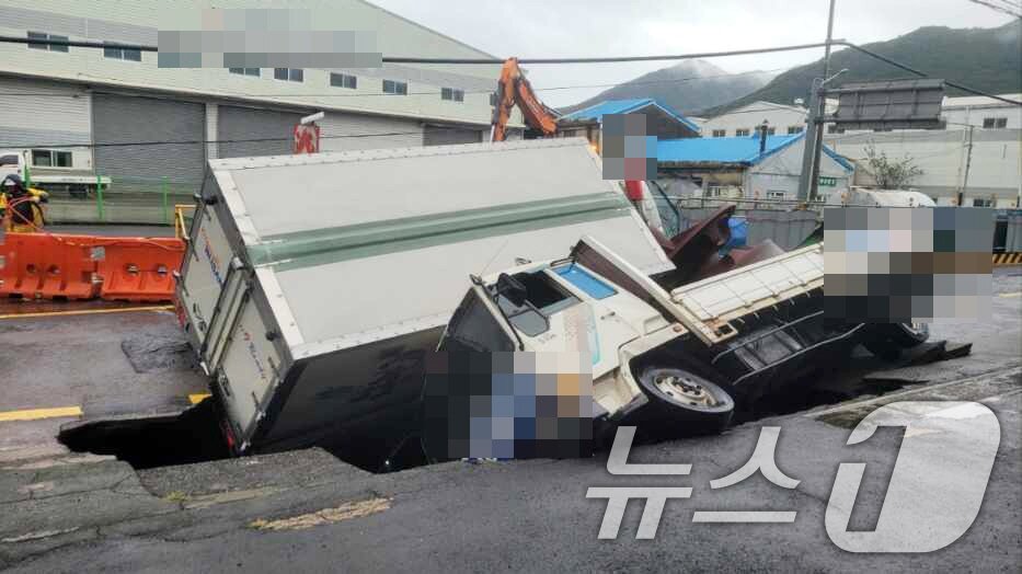 본문 이미지 - 21일 오전 부산 사상구 한 도로에서 가로 10m, 세로 5m, 깊이 8m 가량의 대형 땅꺼짐 현상&#40;싱크홀&#41;이 발생해 도로에서 배수 지원을 하던 삼락119안전센터 배수 차량과 5톤 트럭이 빠져있다. &#40;부산경찰청 제공&#41; 