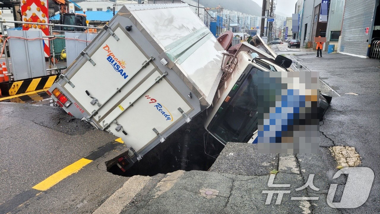 본문 이미지 - 21일 오전 부산 사상구 한 도로에서 가로 10m, 세로 5m, 깊이 8m 가량의 대형 땅꺼짐 현상&#40;싱크홀&#41;이 발생해 도로에서 배수 지원을 하던 삼락119안전센터 배수 차량과 5톤 트럭이 빠져있다. &#40;부산경찰청 제공&#41; 2024.9.21/뉴스1 ⓒ News1 윤일지 기자