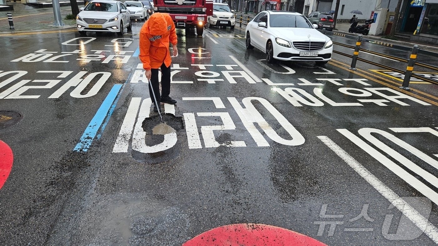 부산 남구 대연동 한 도로에 포트홀이 발생해 소방 당국이 안전조치를 실시하고 있다.&#40;부산소방재난본부 제공&#41;