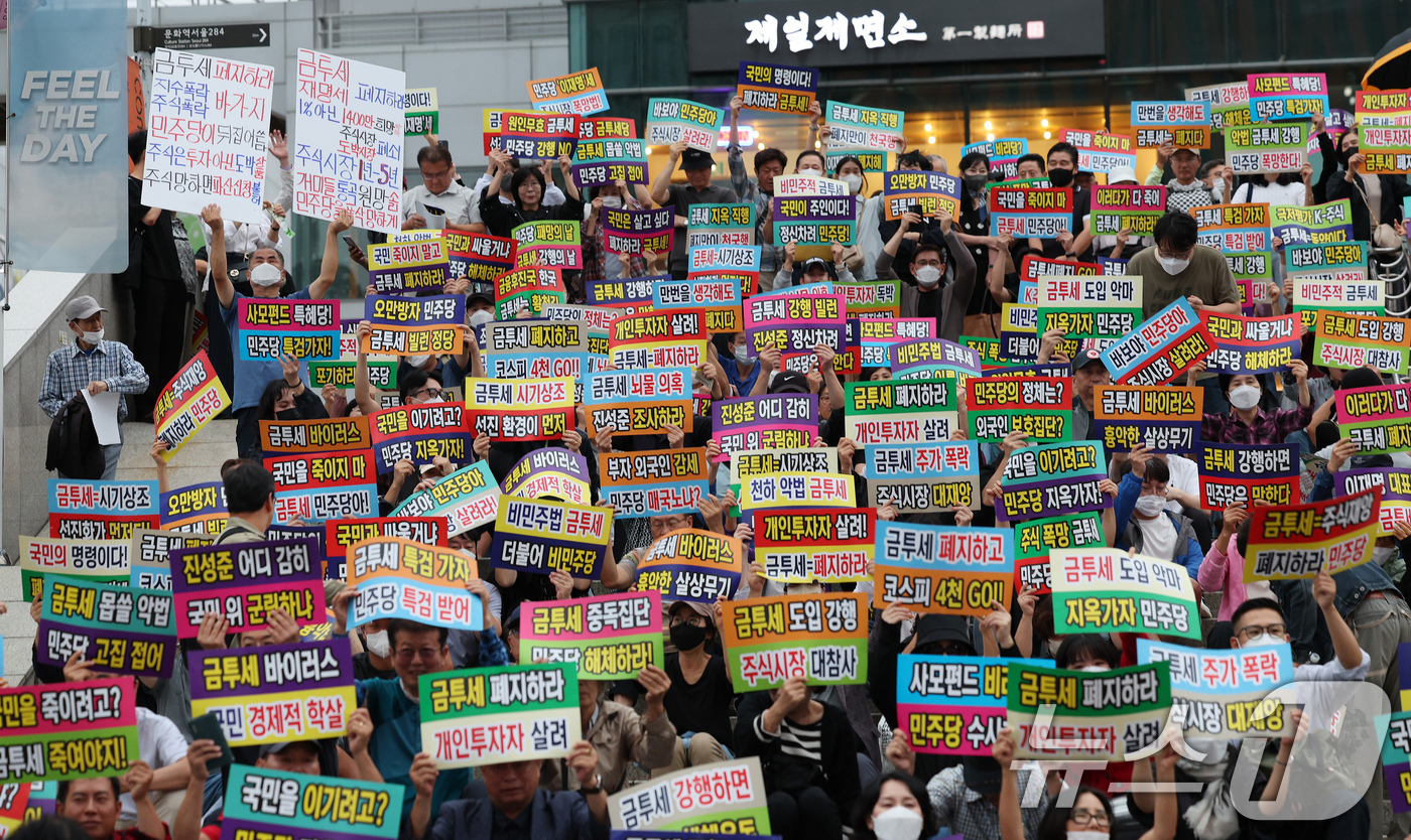 (서울=뉴스1) 장수영 기자 = 한국주식투자자연합회 회원 및 개인투자자들이 21일 오후 서울 중구 서울역 광장에서 금융투자소득세 도입을 반대하는 피켓을 들어보이고 있다. 2024. …