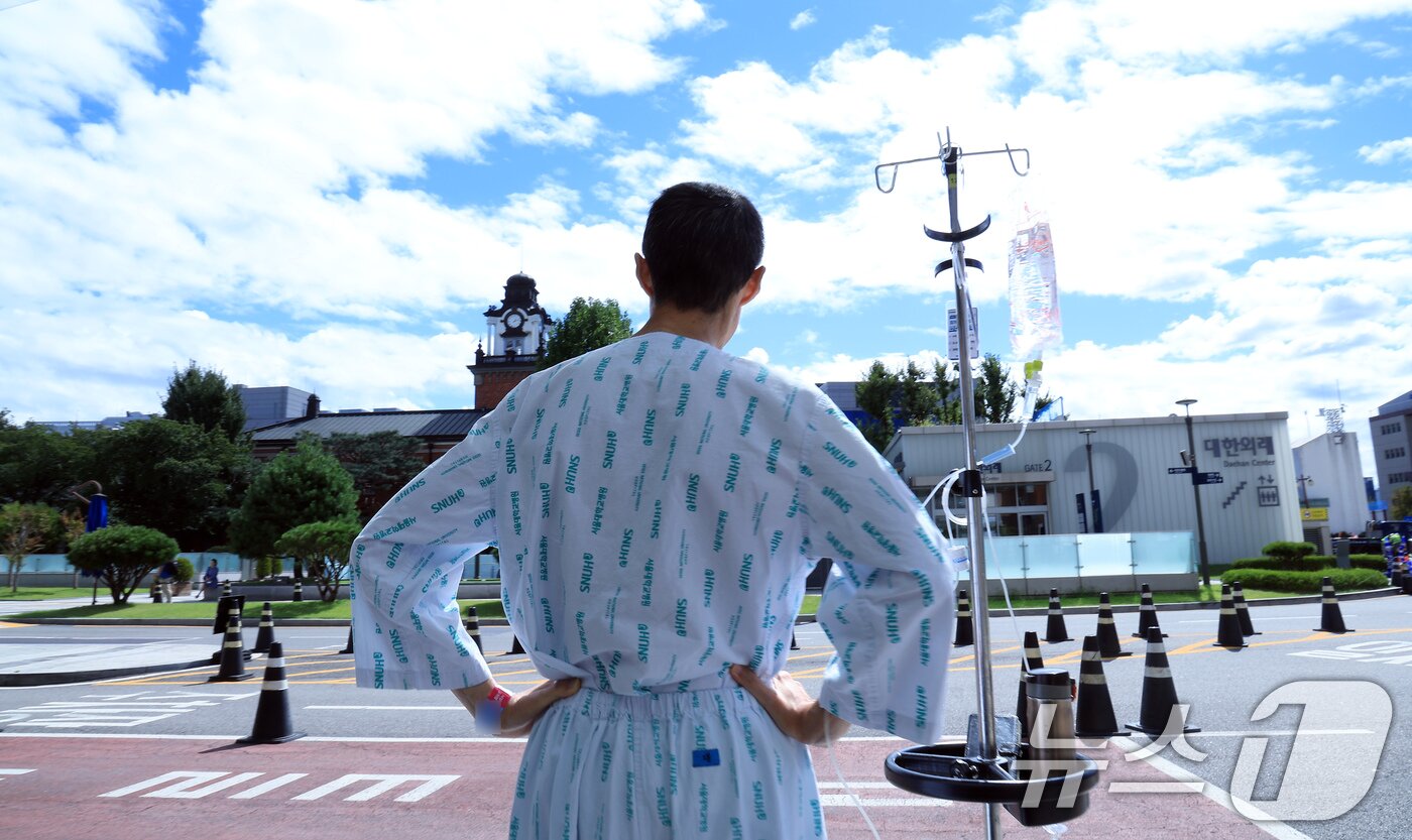 본문 이미지 - 정부의 의대 정원 증원에 반발해 의료계의 집단행동이 이어지고 있는 22일 오후 서울 시내 대학병원 앞에서 환자가 푸른 하늘을 바라보고 있다. 2024.9.22/뉴스1 ⓒ News1 박정호 기자