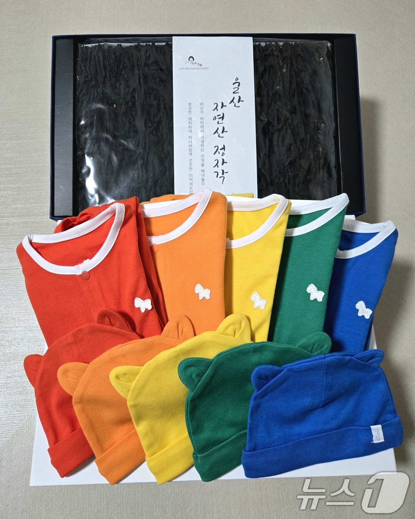 본문 이미지 - 윤석열 대통령은 22일 지난 9월 20일 태어난 다섯쌍둥이 '팡팡레인저'를 위해 준비한 출산 축하 편지와 선물을 유혜미 저출생대응수석을 통해 다섯쌍둥이의 아빠 김준영씨에게 전달했다. 사진은 윤석열 대통령이 준비한 선물. '팡팡레인저'에 어울리는 다섯 가지 색깔의 아기 옷과 산모의 빠른 회복을 위한 자연산 미역. 지난 20일 서울성모병원서 남자아이 3명과 여자아이 2명이 탄생했다. 자연임신으로 오둥이가 태어난 것은 국내 최초로, 세계적으로도 드문 사례다. (대통령실 제공) 2024.9.22/뉴스1 ⓒ News1 박지혜 기자