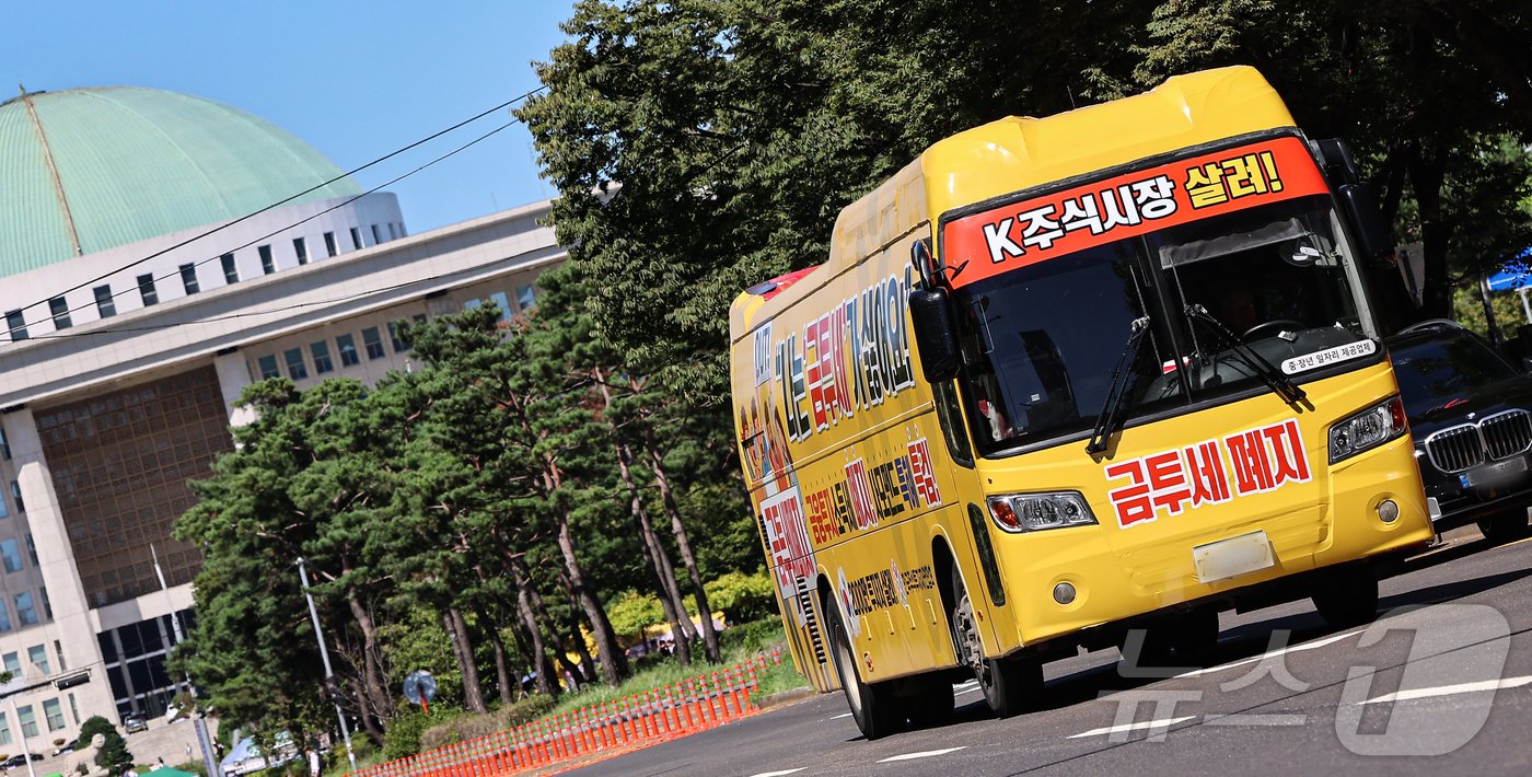 본문 이미지 - 한국주식투자자연합회가 제작한 금융투자소득세 폐지 촉구 집회버스가 23일 서울 영등포구 국회의사당 인근에서 운행되고 있다. 2024.9.23/뉴스1 ⓒ News1 김도우 기자