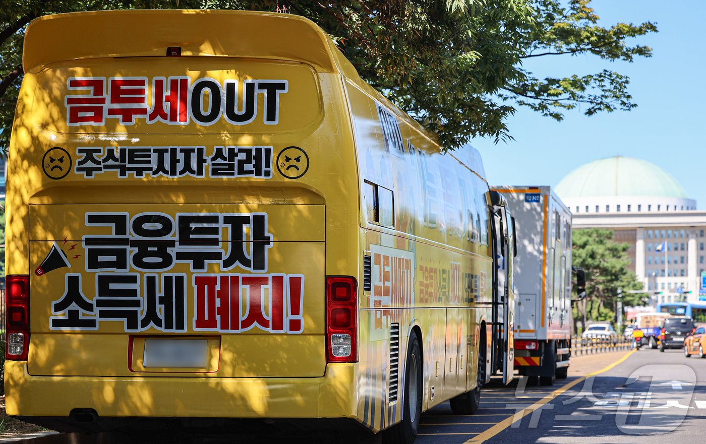 본문 이미지 - 한국주식투자자연합회가 제작한 금융투자소득세 폐지 촉구 집회버스가 23일 서울 영등포구 국회의사당 인근에 정차돼 있다. 2024.9.23/뉴스1 ⓒ News1 김도우 기자