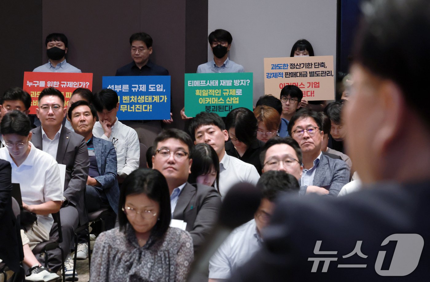 23일 오후 서울 중구 세종대로 한국프레스센터 국제회의장에서 열린 티몬·위메프 사태 재발 방지를 위한 대규모유통업법·전자금융거래법 개정&#40;안&#41; 공청회장 뒤편에서 벤처 협회 관계자들이 정산기한 단축과 판매대금 별도관리안에 대한 반대 입장이 담긴 손피켓을 들고 있다. 2024.9.23/뉴스1 ⓒ News1 박정호 기자