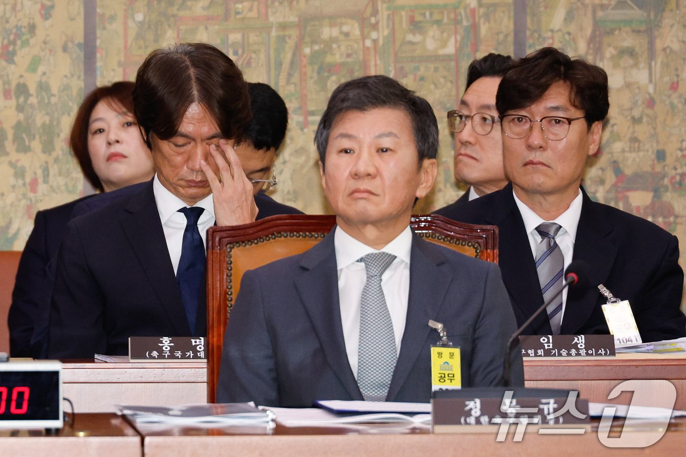 본문 이미지 - 홍명보 남자 축구대표팀 감독이 24일 오전 서울 여의도 국회 문화체육관광위원회에서 열린 대한축구협회 등에 대한 현안질의에 출석해 눈가를 매만지고 있다. 앞줄 오른쪽은 정몽규 대한축구협회장. 2024.9.24/뉴스1 ⓒ News1 안은나 기자