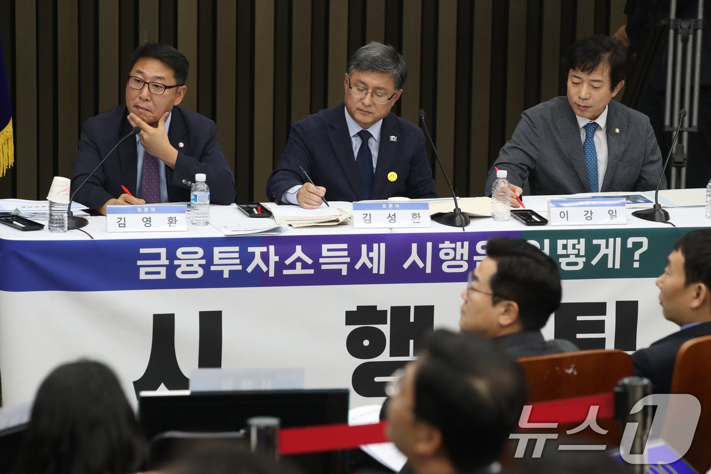 본문 이미지 - 9월 24일 오전 서울 여의도 국회에서 열린 '더불어민주당 정책 디베이트(토론회): '행복하고 정의로운 대한민국, 금융투자소득세 시행은 어떻게?'에서 시행팀 김영환, 김성환, 이강일 의원이 유예팀의 발언을 듣고 있다. 2024.9.24/뉴스1 ⓒ News1 이광호 기자