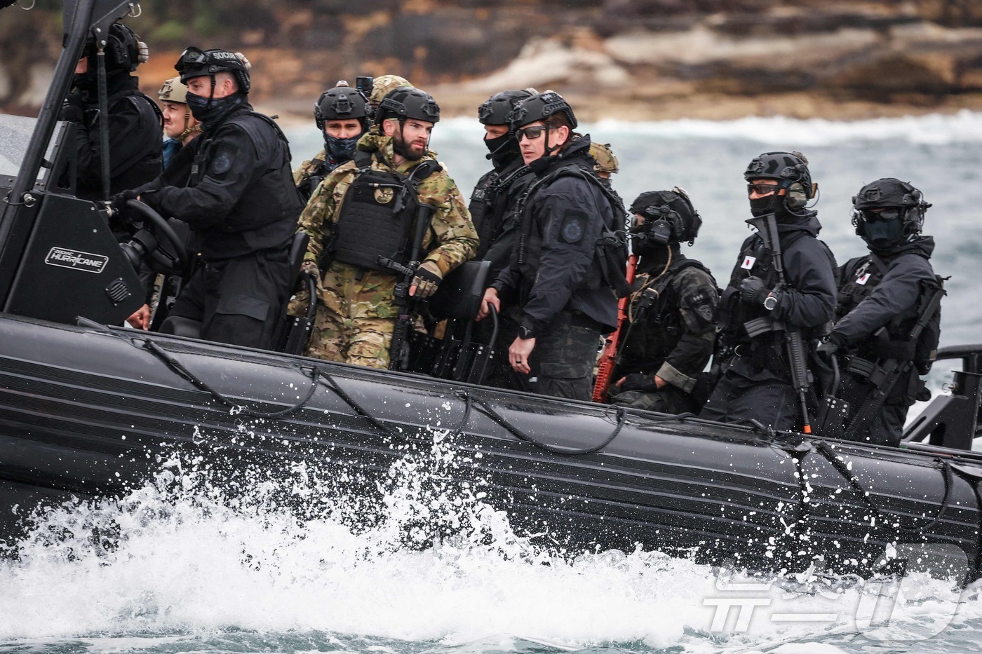 (시드니 AFP=뉴스1) 김지완 기자 = 26일 호주 시드니에서 한국, 미국, 호주 군인들과 일본 자위대원이 보트로 이동하고 있다. 호주 연방경찰과 뉴사우스웨일스주 경찰 병력, 그 …