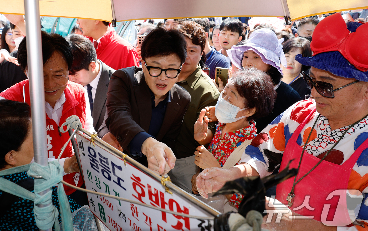 (인천=뉴스1) 안은나 기자 = 한동훈 국민의힘 대표가 박용철 강화군수 후보 10·16 재보궐 선거 지원을 위해 27일 인천 강화풍물시장을 찾아 엿을 구매하고 있다. 2024.9. …