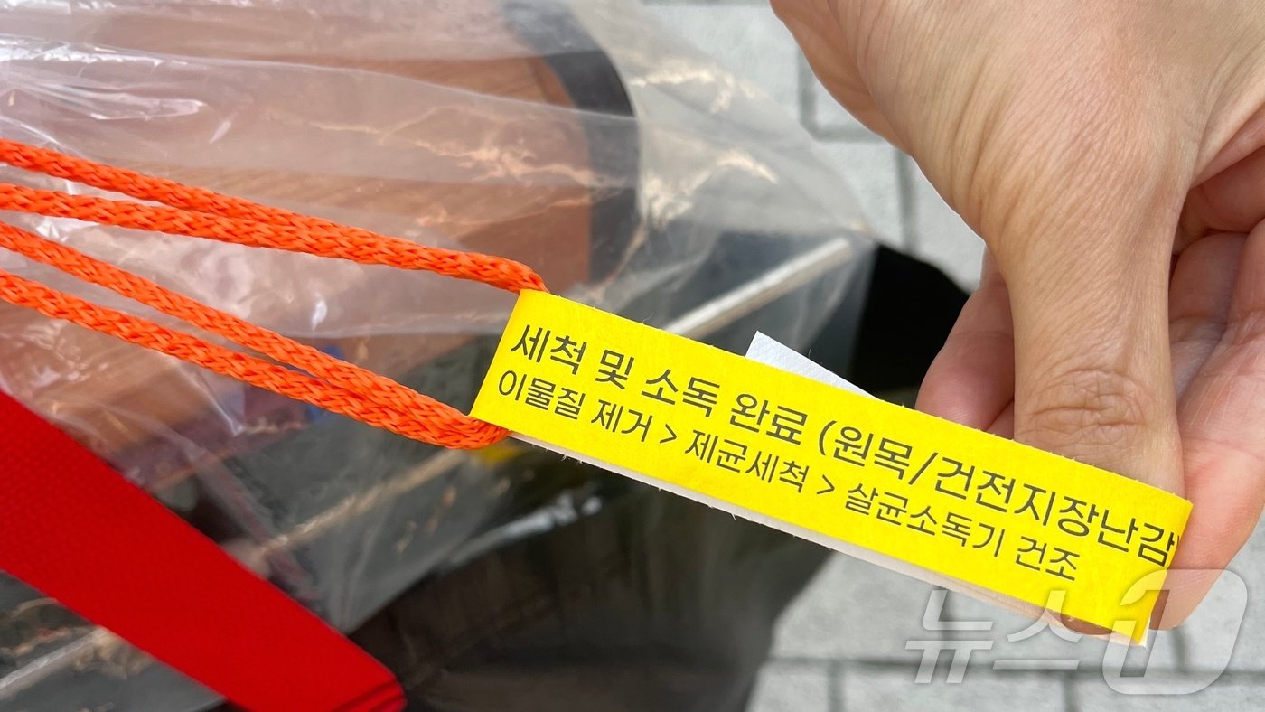 본문 이미지 - 27일 오전 서울 동작구 대방동에서 한 시민이 장난감 소독이 완료됐다는 문구를 들고 있다. 2024.09.27/뉴스1