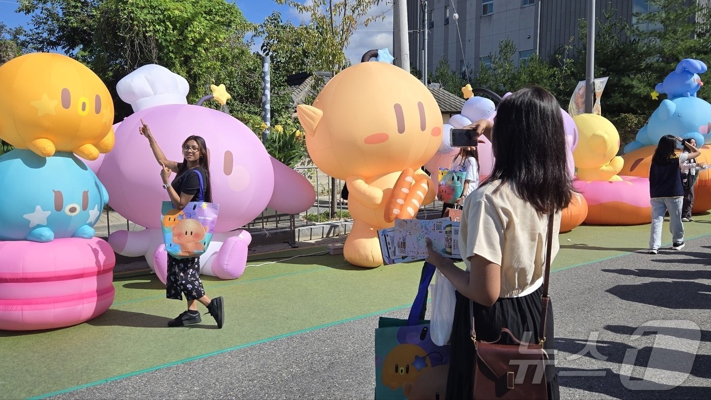본문 이미지 -  29일 대전 소제동에서 열린 '2024 대전 빵축제'에서 한 외국인 관광객이 꿈돌이 조형물을 배경으로 기념사진을 찍고 있다. 2024.9.29 /뉴스1 ⓒ News1 허진실 기자