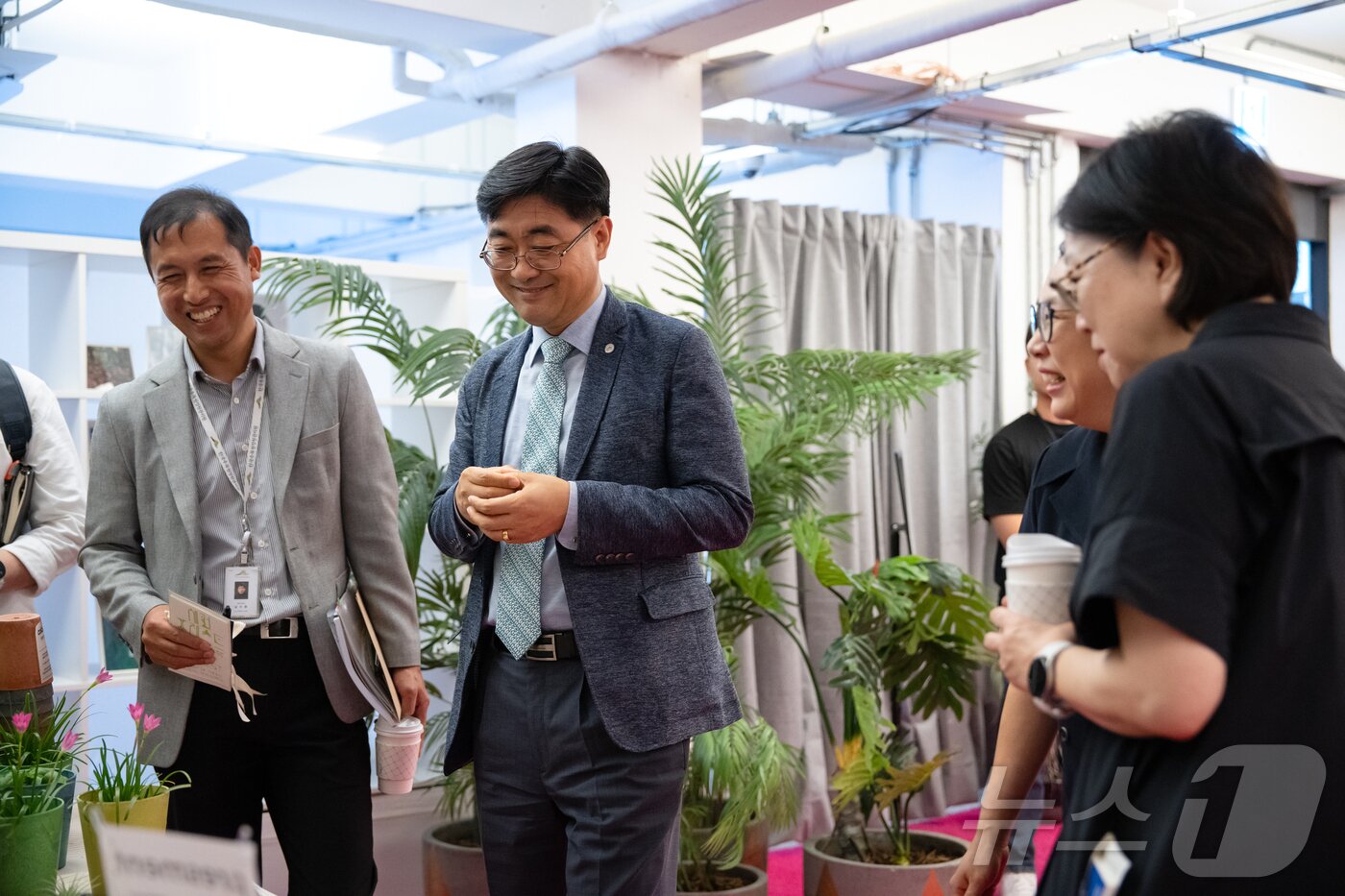 본문 이미지 - 서울 성수동 연무장길에서 열린 ‘디지털 치유정원’ 팝업 전시에 참석한 한국수목원정원관리원 심상택 이사장(왼쪽 두 번째)이 전시를 관람하고 있다.(한국수목원정원관리원 제공) /뉴스1 