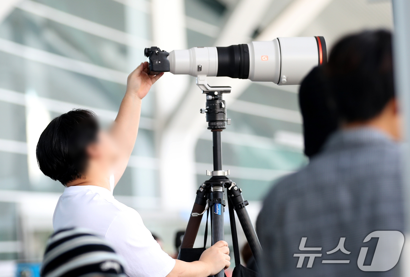 (인천공항=뉴스1) 권현진 기자 = 30일 오전 인천국제공항 입국장 앞에 프랑스 파리로 출국하는 장원영의 모습을 카메라에 담기위해 한 팬이 망원렌즈를 셋팅하며 그를 기다리고 있다. …