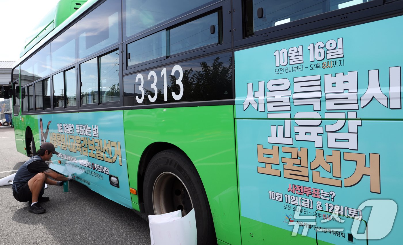 본문 이미지 - 30일 서울시 송파구 송파공영차고지에서 서울시선관위 관계자들이 오는 10월 16일 실시하는 서울특별시 교육감보궐선거의 투표일 등을 알리는 시내버스 래핑 홍보를 하고 있다. 2024.9.30/뉴스1 ⓒ News1 김명섭 기자