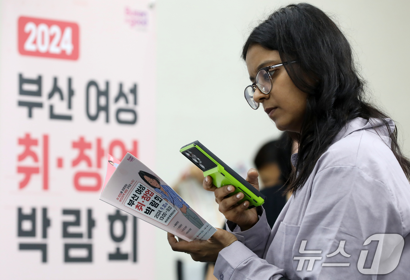 (부산=뉴스1) 윤일지 기자 = 30일 오후 부산 연제구 부산시청에서 열린 '2024 부산 여성 취·창업 박람회'에서 외국인 구직자가 면접을 기다리며 채용정보를 살펴보고 있다.경력 …