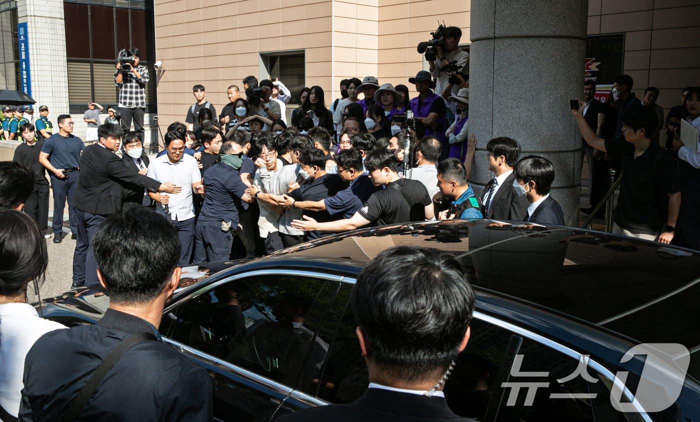 본문 이미지 - 이태원 참사 부실대응 등의 혐의를 받는 이임재 전 용산경찰서장이 30일 오후 서울 마포구 서울 서부지방법원에서 열린 선고공판을 마치고 차량으로 법원을 나서고 있다. 경찰 벽 너머로 이태원 참사 유가족협의회 구성원들이 차량을 바라보고 있다. 2024.9.30/뉴스1 ⓒ News1 이승배 기자