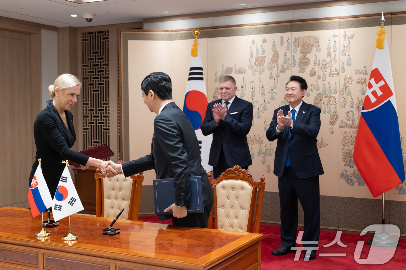 안덕근 산업통상자원부 장관과 데니사 사코바 슬로바키아 부총리 겸 경제부 장관이 30일 서울 용산 대통령실 청사에서 윤석열 대통령과 로베르트 피초 슬로바키아 총리가 임석한 가운데 열린 양해각서&#40;MOU&#41; 서명식에서 무역투자촉진프레임워크&#40;TIPF&#41; 수립 및 포괄적 에너지 협력 MOU에 서명 뒤 문서를 교환하고 있다. &#40;대통령실 제공&#41; 2024.9.30/뉴스1 ⓒ News1 송원영 기자