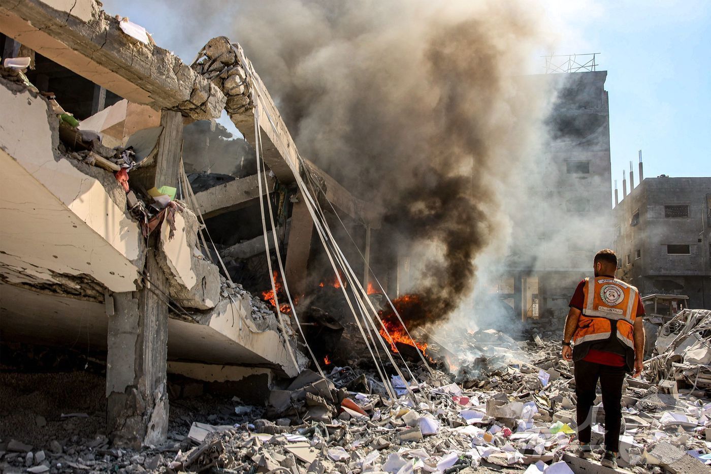본문 이미지 - 3일(현지시간) 가자지구 북부 셰이크 라드완에서 이스라엘의 폭격으로 화재가 발생한 건물 앞에 팔레스타인 민방위 대원이 서 있다. 2024.09.03 ⓒ AFP=뉴스1 ⓒ News1 유수연 기자