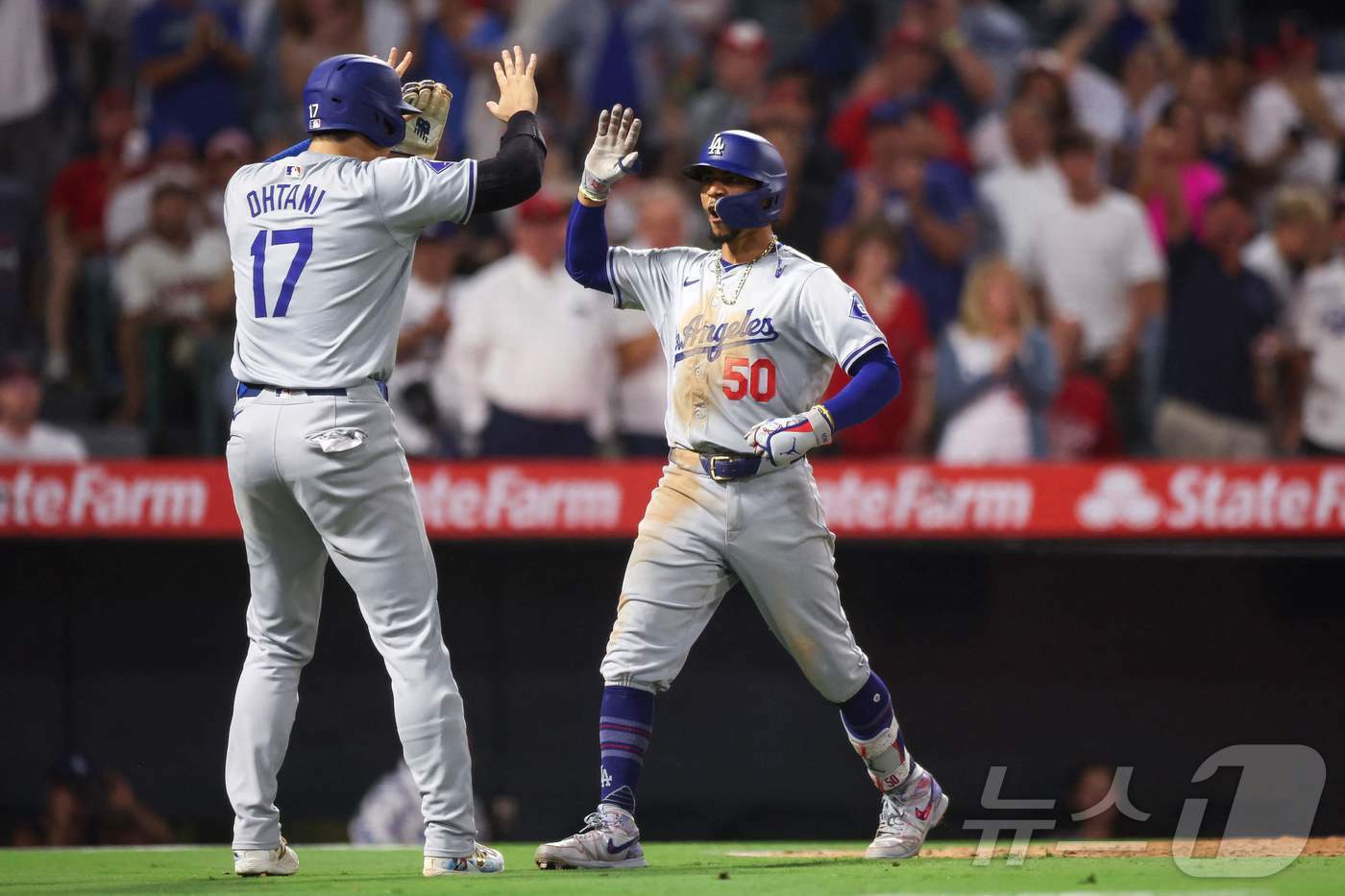 본문 이미지 - 연장 10회 3점 홈런을 때려낸 무키 베츠와 하이파이브를 하고 있는 오타니. ⓒ AFP=뉴스1