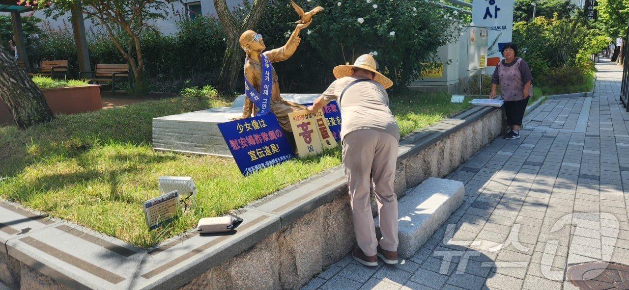 4일 오전 경남교육청 제2청사에 설치된 일본군 위안부 소녀상에 신원미상의 남성이 혐오 표현이 적힌 손피켓을 놓고 있다.&#40;독자 제공&#41;